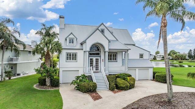 2118 Harbour Watch Dr, Tarpon Springs, FL 34689 - view of front of property with an attached garage, a water view, concrete driveway, and a front yard