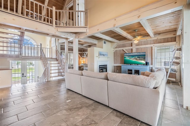 living room featuring a healthy amount of sunlight, a high ceiling, and wooden ceiling