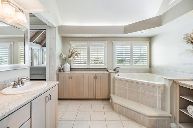 bathroom featuring lofted ceiling with beams, tiled tub, tile patterned flooring, and plenty of natural light