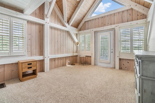 interior space featuring wood walls, carpet flooring, wooden ceiling, and beam ceiling