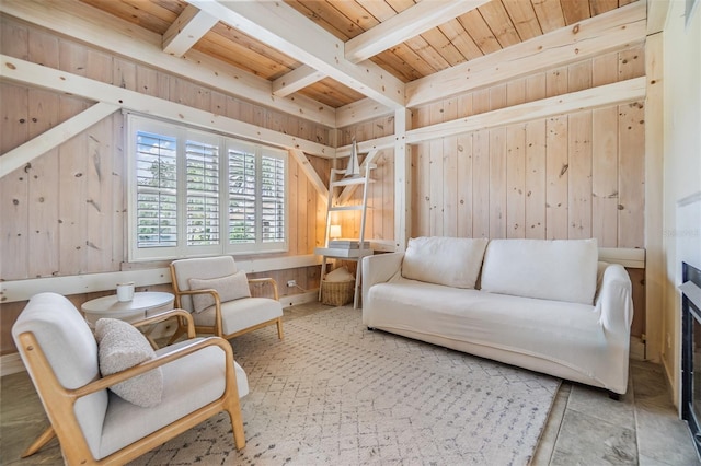 sitting room with wood walls, beamed ceiling, and wood ceiling