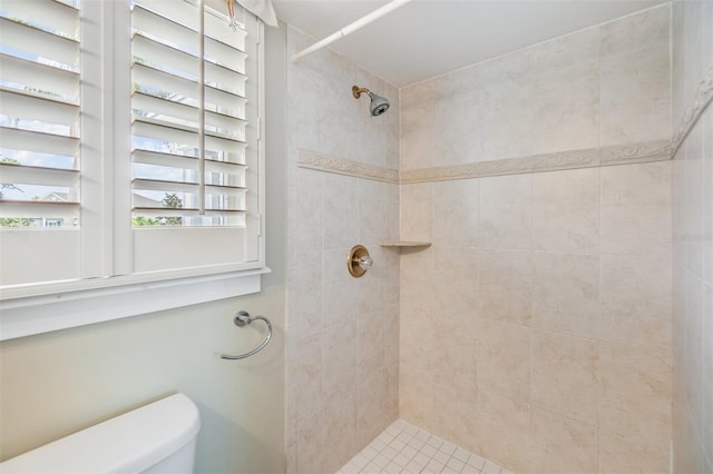 bathroom with toilet and a tile shower