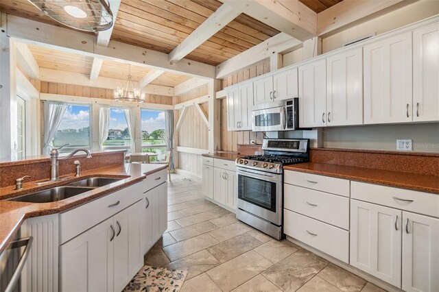 2118 Harbour Watch Dr, Tarpon Springs, FL 34689 - kitchen with appliances with stainless steel finishes, a sink, wooden ceiling with exposed beams, white cabinets, and a chandelier