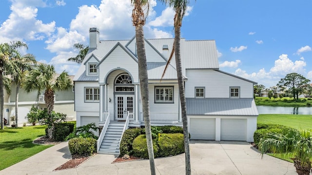 view of front facade with a garage, a water view, and a front yard