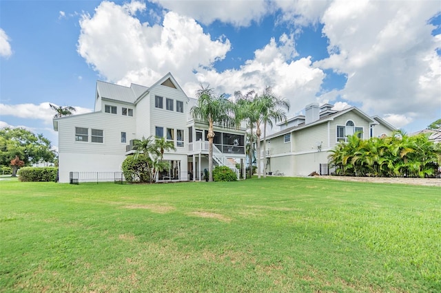 back of property featuring a lawn and a sunroom