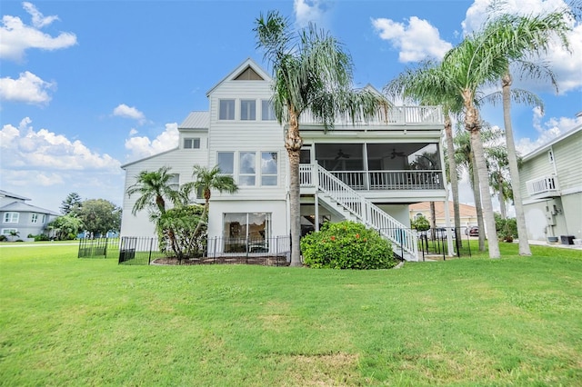 back of house with ceiling fan, a sunroom, and a yard