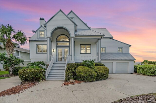 2118 Harbour Watch Dr, Tarpon Springs, FL 34689 - view of front of house with french doors, concrete driveway, metal roof, and a garage