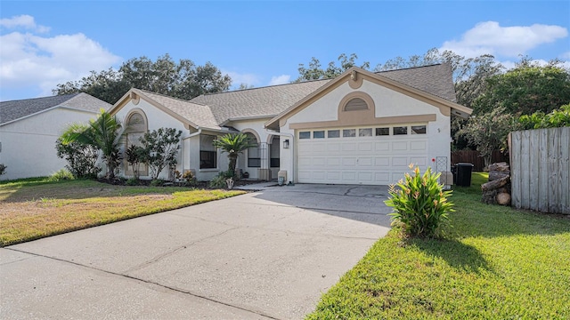 ranch-style house featuring a garage and a front lawn