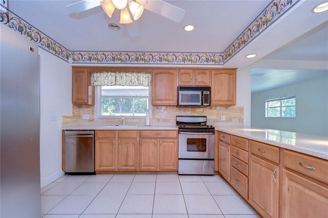 kitchen with light tile patterned floors, sink, ceiling fan, decorative backsplash, and appliances with stainless steel finishes