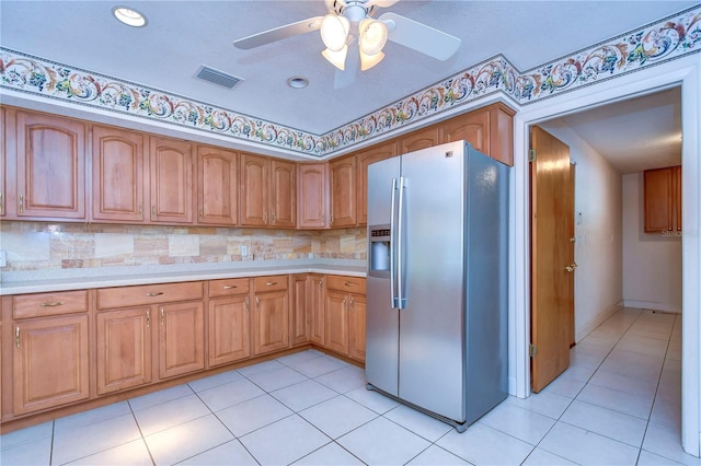 kitchen with stainless steel fridge with ice dispenser, tasteful backsplash, light tile patterned floors, and ceiling fan