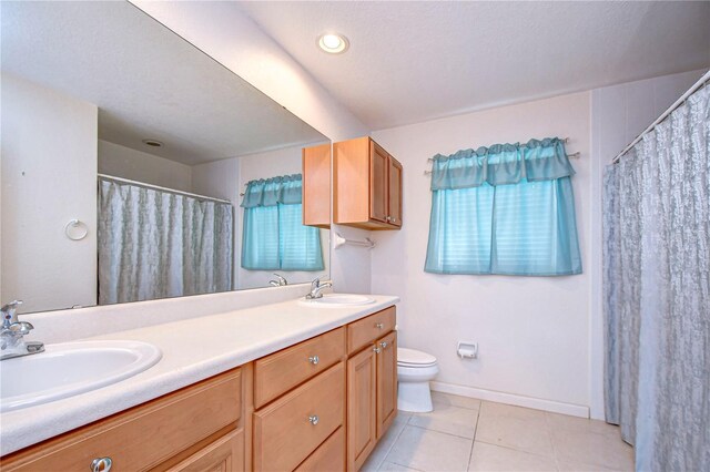 bathroom featuring tile patterned floors, toilet, a textured ceiling, and vanity