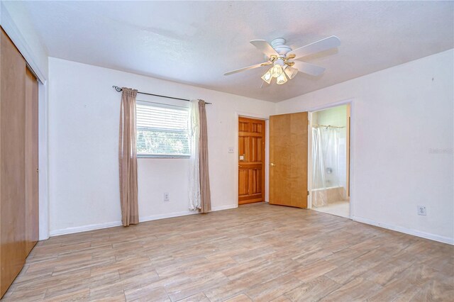 unfurnished bedroom featuring ensuite bathroom, ceiling fan, and light hardwood / wood-style floors