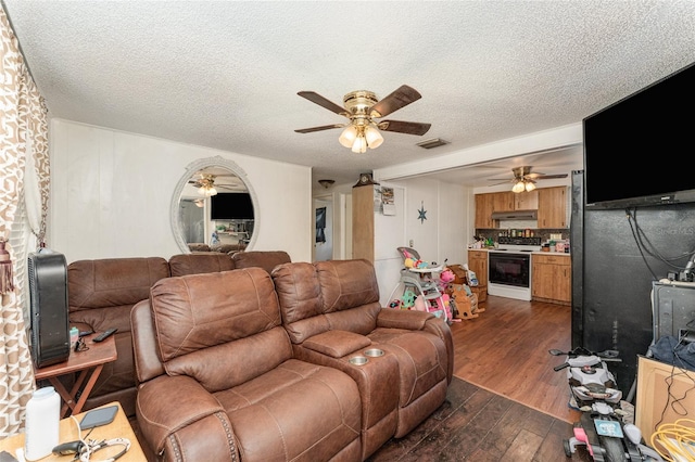 living room featuring ceiling fan, dark hardwood / wood-style flooring, and a textured ceiling