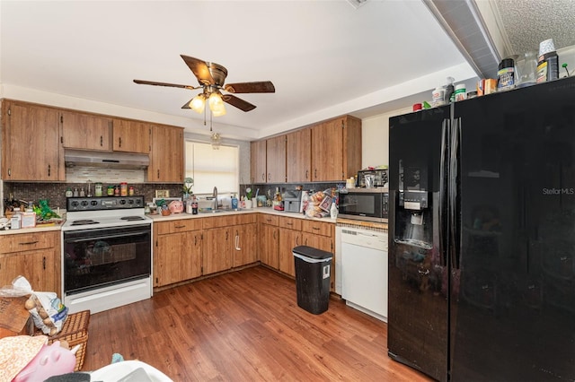 kitchen featuring white appliances, dark hardwood / wood-style flooring, sink, decorative backsplash, and ceiling fan