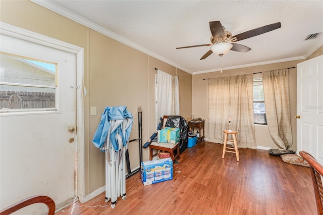 miscellaneous room featuring hardwood / wood-style floors, ceiling fan, a textured ceiling, and ornamental molding