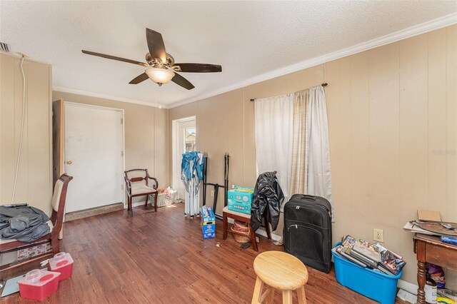 misc room with ceiling fan, dark hardwood / wood-style floors, crown molding, and a textured ceiling