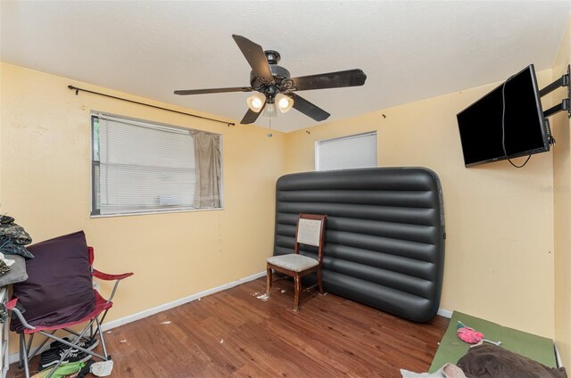 living area with ceiling fan and hardwood / wood-style flooring