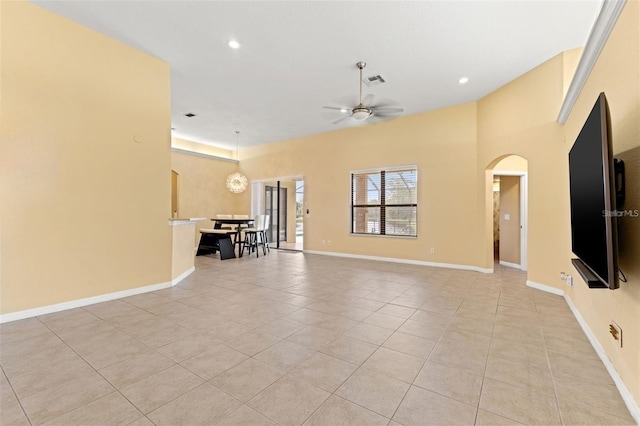 unfurnished living room with ceiling fan with notable chandelier and light tile patterned floors