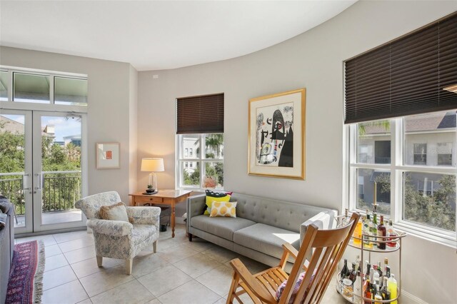 living area featuring french doors, a healthy amount of sunlight, and light tile patterned flooring