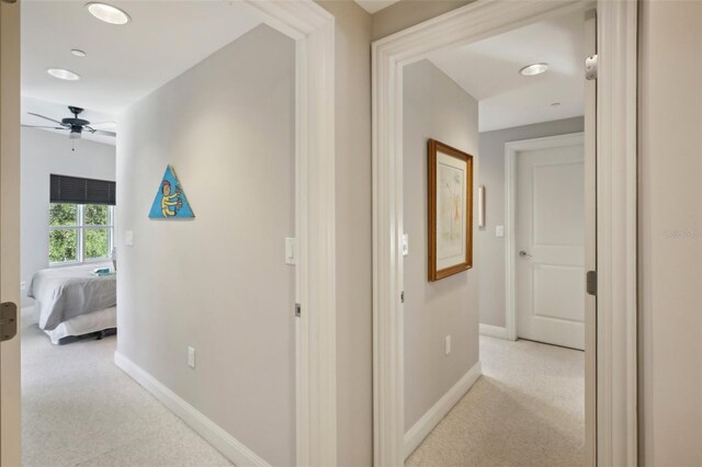 hallway with baseboards and carpet flooring