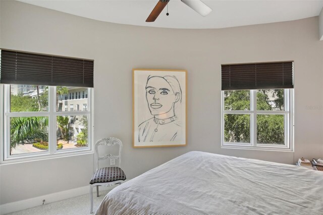 carpeted bedroom with ceiling fan and baseboards