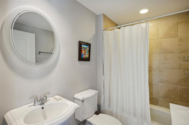 full bathroom with shower / tub combo, a sink, toilet, and recessed lighting