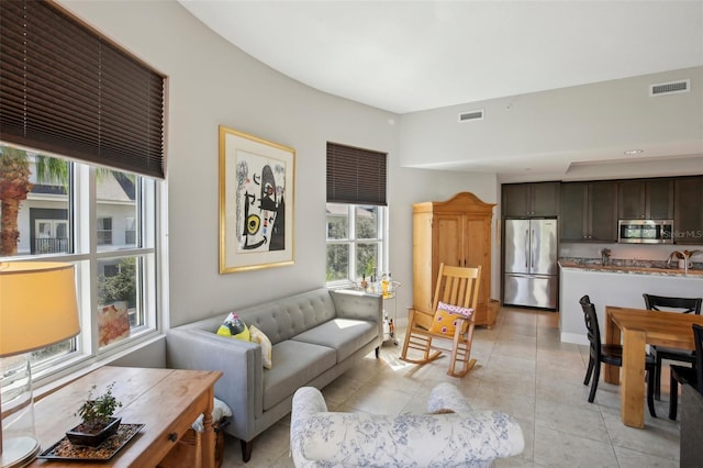 living area featuring visible vents and light tile patterned flooring