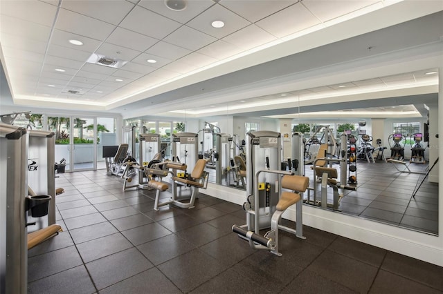 workout area with visible vents, a raised ceiling, and a paneled ceiling