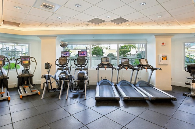 exercise room featuring a drop ceiling, visible vents, and baseboards