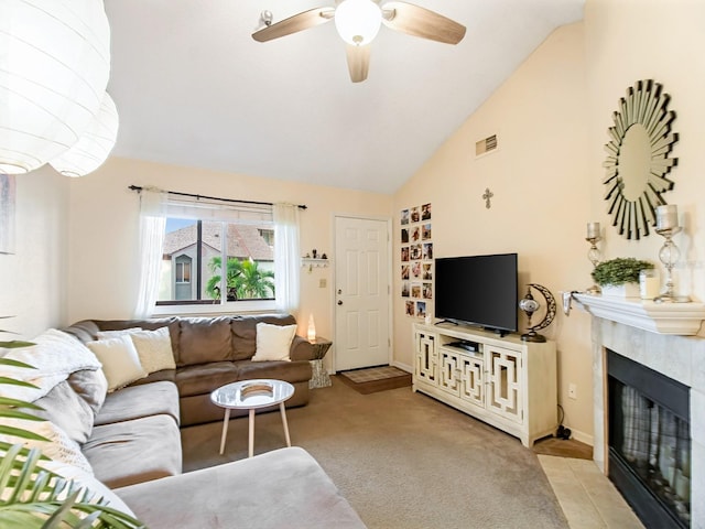 living room with light colored carpet, ceiling fan, a tiled fireplace, and high vaulted ceiling