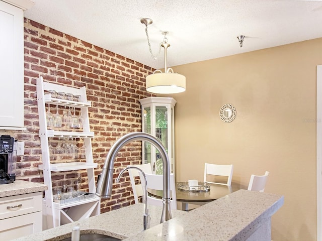 dining area with a textured ceiling and brick wall