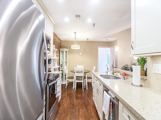 kitchen with white cabinets, appliances with stainless steel finishes, dark hardwood / wood-style floors, and sink