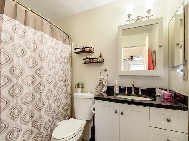 bathroom featuring a textured ceiling, vanity, walk in shower, toilet, and ceiling fan