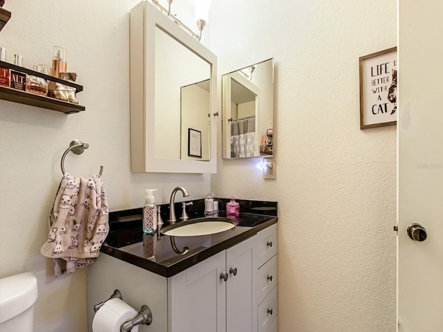 bathroom featuring vanity and toilet