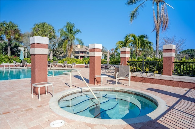 view of swimming pool featuring a community hot tub and a patio area