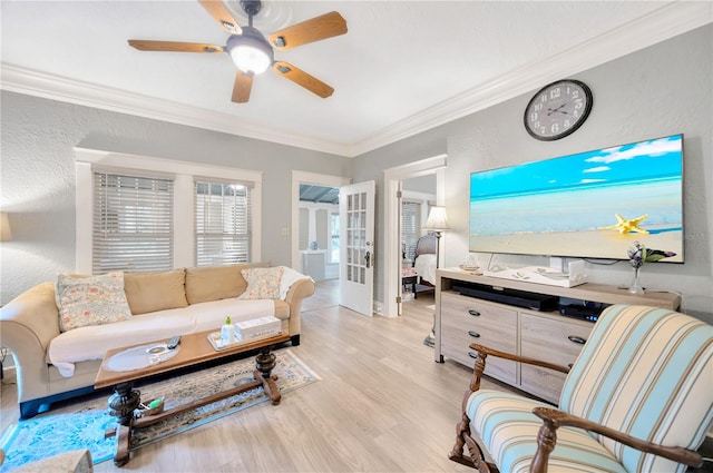 living room with light wood-type flooring, ceiling fan, crown molding, and french doors