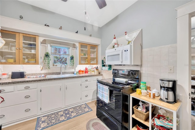 kitchen with electric range, sink, white cabinetry, and light hardwood / wood-style floors