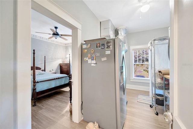 bedroom featuring light wood-type flooring, stainless steel fridge, and ceiling fan