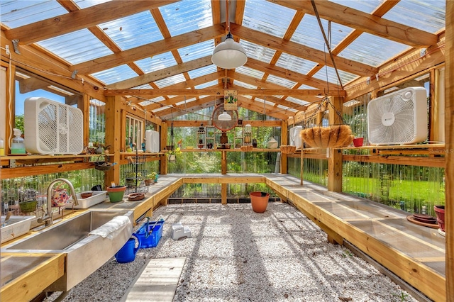 unfurnished sunroom featuring vaulted ceiling with beams