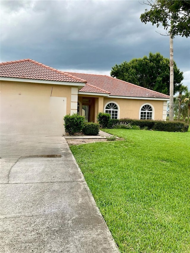 mediterranean / spanish-style house featuring a front lawn