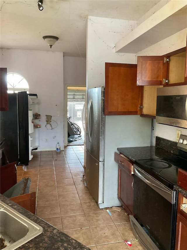 kitchen with appliances with stainless steel finishes and light tile patterned flooring