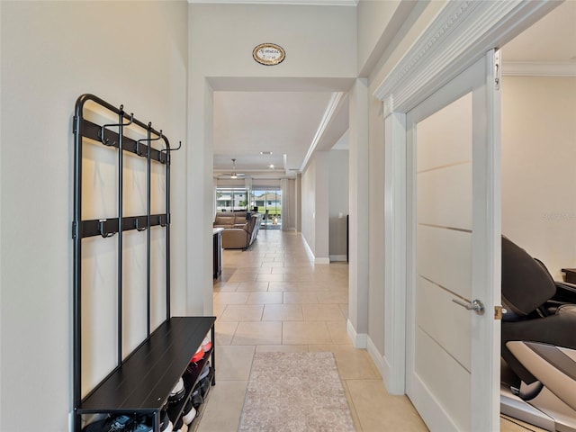 hallway with ornamental molding and light tile patterned flooring