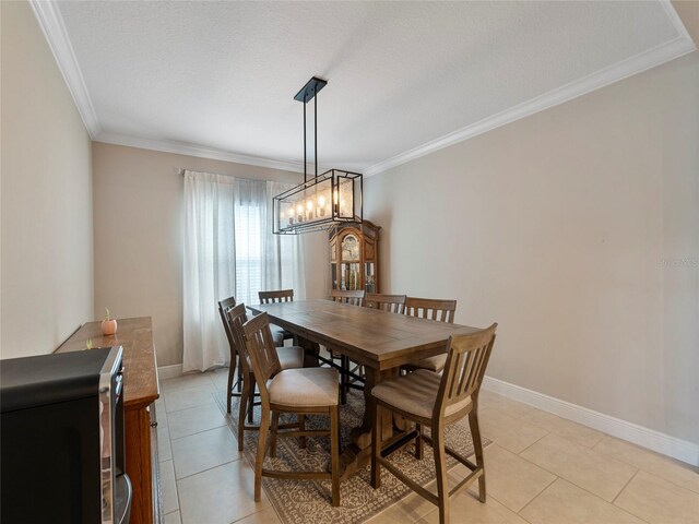 tiled dining room featuring crown molding and an inviting chandelier