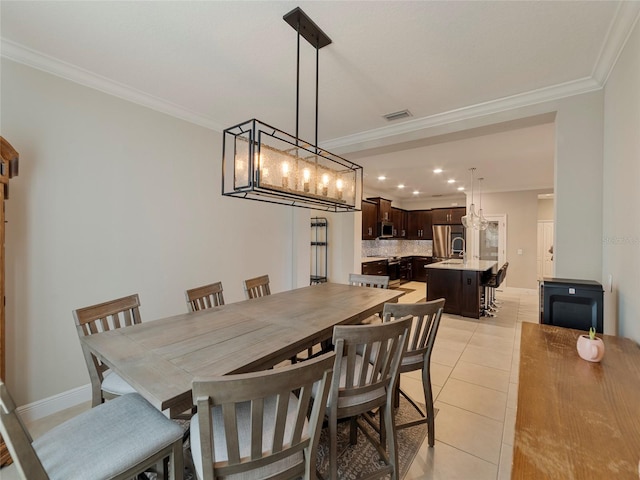 dining area with crown molding and light tile patterned floors