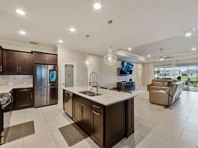 kitchen with backsplash, appliances with stainless steel finishes, sink, ceiling fan, and light stone counters