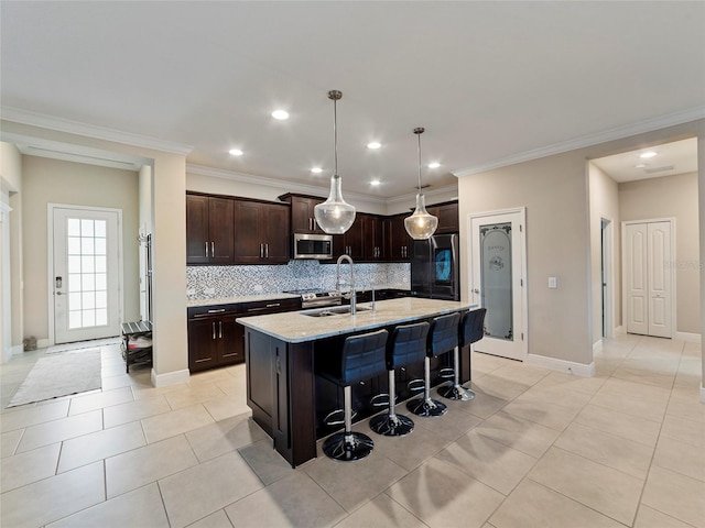 kitchen with tasteful backsplash, a kitchen bar, stainless steel appliances, light stone countertops, and a center island with sink