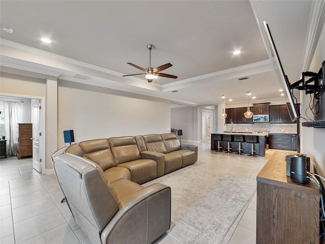 tiled living room featuring crown molding and ceiling fan