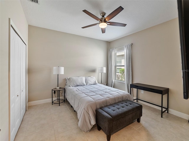 bedroom featuring light tile patterned flooring, ceiling fan, and a closet