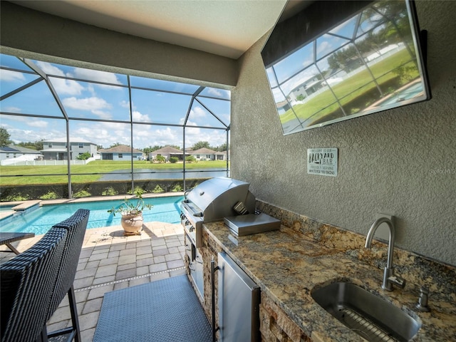 view of patio / terrace with area for grilling, an outdoor kitchen, glass enclosure, and sink