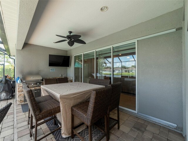 view of patio / terrace with exterior kitchen, a grill, and ceiling fan